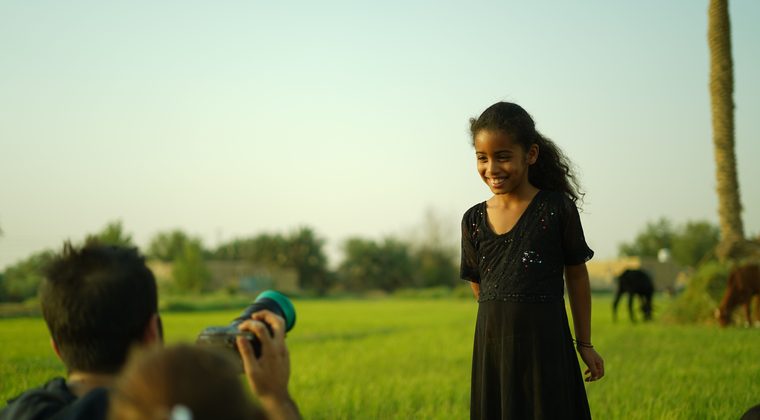 A child being photographed in a field